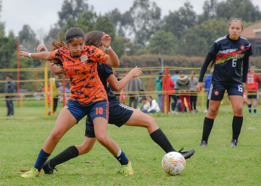 Active female athletes playing soccer on a grass field